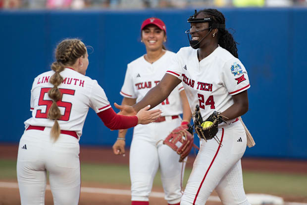 Women smile on the softball field.