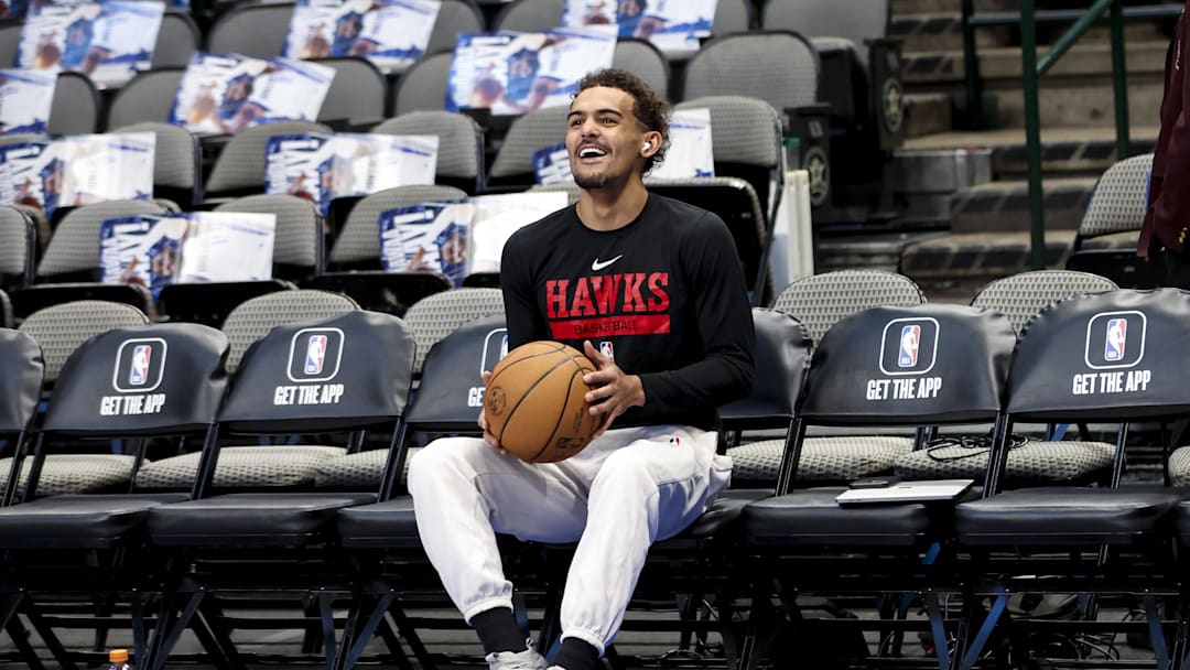 Trae Young laughing on the bench before a game against the Dallas Mavericks