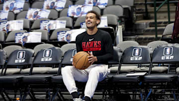 Trae Young laughing on the bench before a game against the Dallas Mavericks