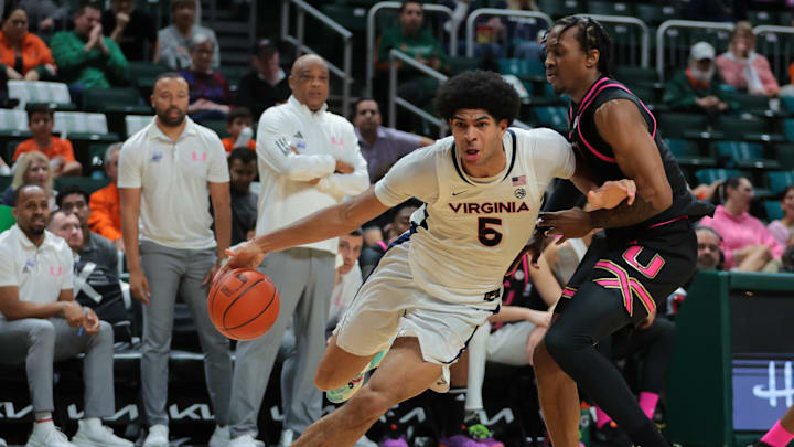 Jan 29, 2025; Coral Gables, Florida, USA; Virginia Cavaliers forward Jacob Cofie (5) drives o the basket past Miami Hurricanes guard Paul Djobet (10) during the first half at Watsco Center. Mandatory Credit: Sam Navarro-Imagn Images