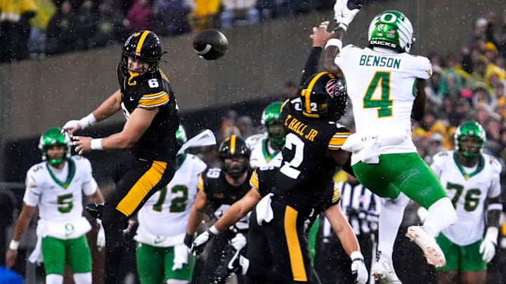 Iowa Hawkeyes defensive back Zach Lutmer (6) and Iowa Hawkeyes defensive back TJ Hall (2) defend a pass meant for Oregon Ducks wide receiver Malik Benson (4) Nov. 8, 2025 during a Big Ten Football game at Kinnick Stadium in Iowa City, Iowa.