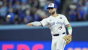Nov 1, 2025; Toronto, Ontario, CAN; Toronto Blue Jays designated hitter Bo Bichette (11) throws to first for an out against Los Angeles Dodgers second baseman Tommy Edman (25) in the eighth inning during game seven of the 2025 MLB World Series at Rogers Centre. Mandatory Credit: John E. Sokolowski-Imagn Images