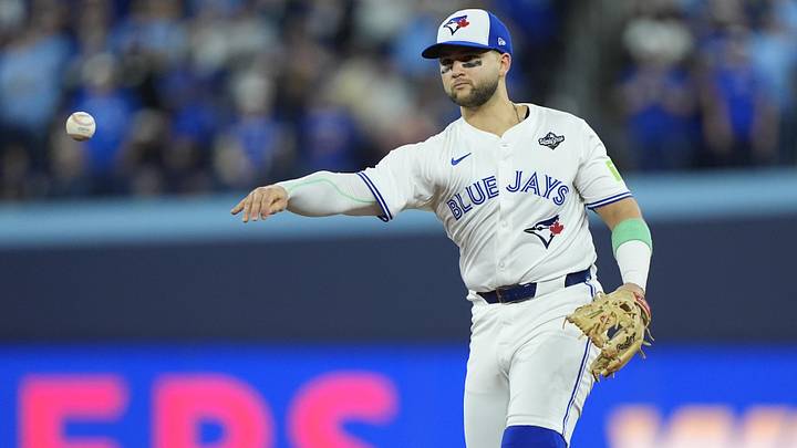 Nov 1, 2025; Toronto, Ontario, CAN; Toronto Blue Jays designated hitter Bo Bichette (11) throws to first for an out against Los Angeles Dodgers second baseman Tommy Edman (25) in the eighth inning during game seven of the 2025 MLB World Series at Rogers Centre. Mandatory Credit: John E. Sokolowski-Imagn Images