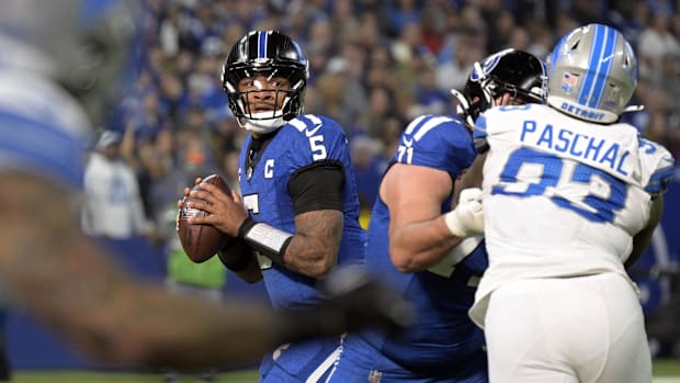 Colts quarterback Anthony Richardson (blue uniform) looks downfield to throw the football.