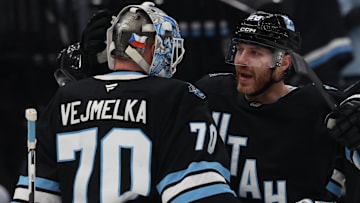 Mar 20, 2025; Salt Lake City, Utah, USA; Utah Hockey Club goaltender Karel Vejmelka (70) and defenseman Ian Cole (28) celebrate a win over the Buffalo Sabres after the game at Delta Center. Mandatory Credit: Rob Gray-Imagn Images