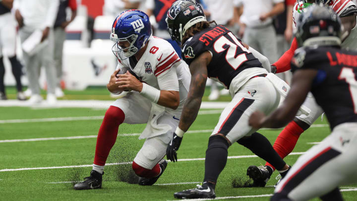 Aug 17, 2024; Houston, Texas, USA;  New York Giants quarterback Daniel Jones (8) scrambles 16 yards and slides against Houston Texans cornerback Derek Stingley Jr. (24) in the first quarter at NRG Stadium.  