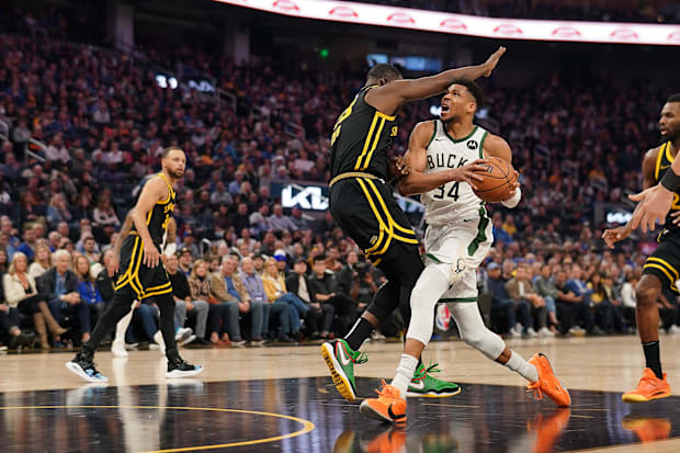 Milwaukee Bucks forward Giannis Antetokounmpo (34) runs into Golden State Warriors forward Draymond Green (23)