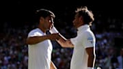 Carlos Alcaraz and Fabio Fognini hug after a Wimbledon match.