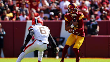 Oct 6, 2024; Landover, Maryland, USA; Washington Commanders quarterback Jayden Daniels (5) runs the ball against Cleveland Browns linebacker Jeremiah Owusu-Koramoah (6) during the first quarter at NorthWest Stadium. Mandatory Credit: Peter Casey-Imagn Images