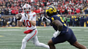 Nov 29, 2025; Ann Arbor, Michigan, USA; Ohio State Buckeyes quarterback Julian Sayin (10) runs the ball pressured by Michigan Wolverines defensive end Cameron Brandt (9) in the first half at Michigan Stadium. Mandatory Credit: Rick Osentoski-Imagn Images