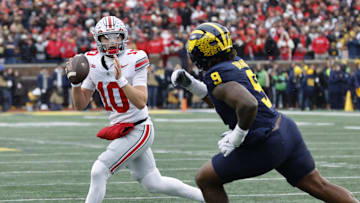 Nov 29, 2025; Ann Arbor, Michigan, USA; Ohio State Buckeyes quarterback Julian Sayin (10) runs the ball pressured by Michigan Wolverines defensive end Cameron Brandt (9) in the first half at Michigan Stadium. Mandatory Credit: Rick Osentoski-Imagn Images