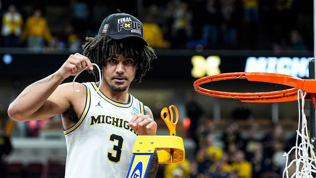 Michigan guard Elliot Cadeau (3) cuts down net to celebrate 95-62 win over Tennessee at the NCAA Tournament Midwest Regional Final at United Center in Chicago on Sunday, March 29, 2026.