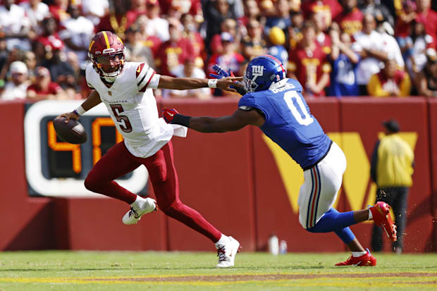 Jayden Daniels tries to evade Brian Burns.