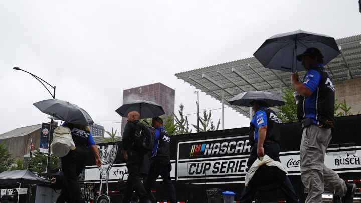 Jul 2, 2023; Chicago, Illinois, USA;  Crew members walk in heavy rain along Grant Park to resume the start of The Loop 121 of the Chicago Street Race. 