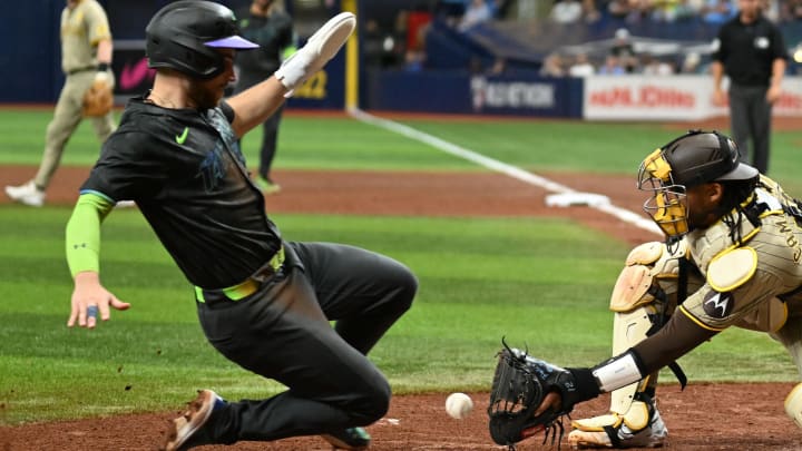 Aug 31, 2024; St. Petersburg, Florida, USA; Tampa Bay Rays first baseman Brandon Lowe (8) slides safe at home as San Diego Padres catcher Kyle Higashioka (20) waits for the ball in the fourth inning  at Tropicana Field. Mandatory Credit: Jonathan Dyer-USA TODAY Sports