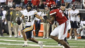 Cal wide receiver Jacob De Jesus tries to elude Louisville defender 