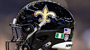 Sep 7, 2025; New Orleans, Louisiana, USA;  Detailed view of the helmet worn by New Orleans Saints safety Ugo Amadi (0) with and American Flag and the flag of Nigeria during warmups against the Arizona Cardinals at Caesars Superdome. Mandatory Credit: Stephen Lew-Imagn Images