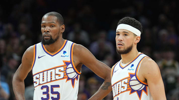 Phoenix Suns forward Kevin Durant and guard Devin Booker look on during a game. Phoenix Suns forward Kevin Durant and guard Devin Booker look on during a game.
