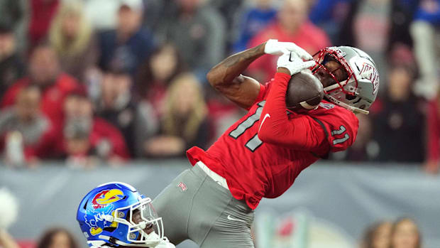 UNLV Rebels wide receiver Ricky White catches a touchdown pass against Kansas Jayhawks cornerback Cobee Bryant. 