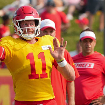 Jul 26, 2024; Kansas City, MO, USA; Kansas City Chiefs Kansas City Chiefs quarterback Carson Wentz (11) throws a pass as general manager Brett Veach watches in the background during training camp at Missouri Western State University. Mandatory Credit: Denny Medley-USA TODAY Sports