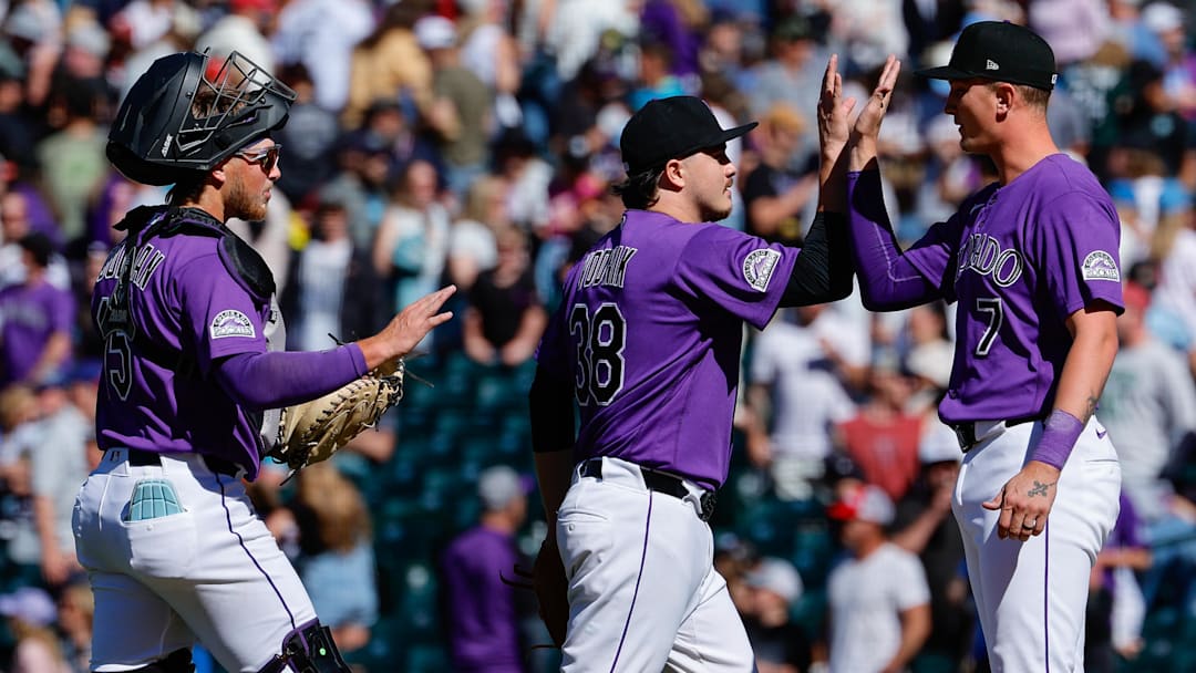 Colorado Rockies relief pitcher Victor Vodnik (38) and catcher Hunter Goodman (15) celebrate with designated hitter TJ Rumfield (7) after the game. 