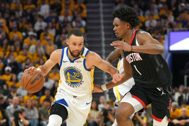 Golden State Warriors guard Stephen Curry (30) dribbles against Houston Rockets forward Amen Thompson (1)