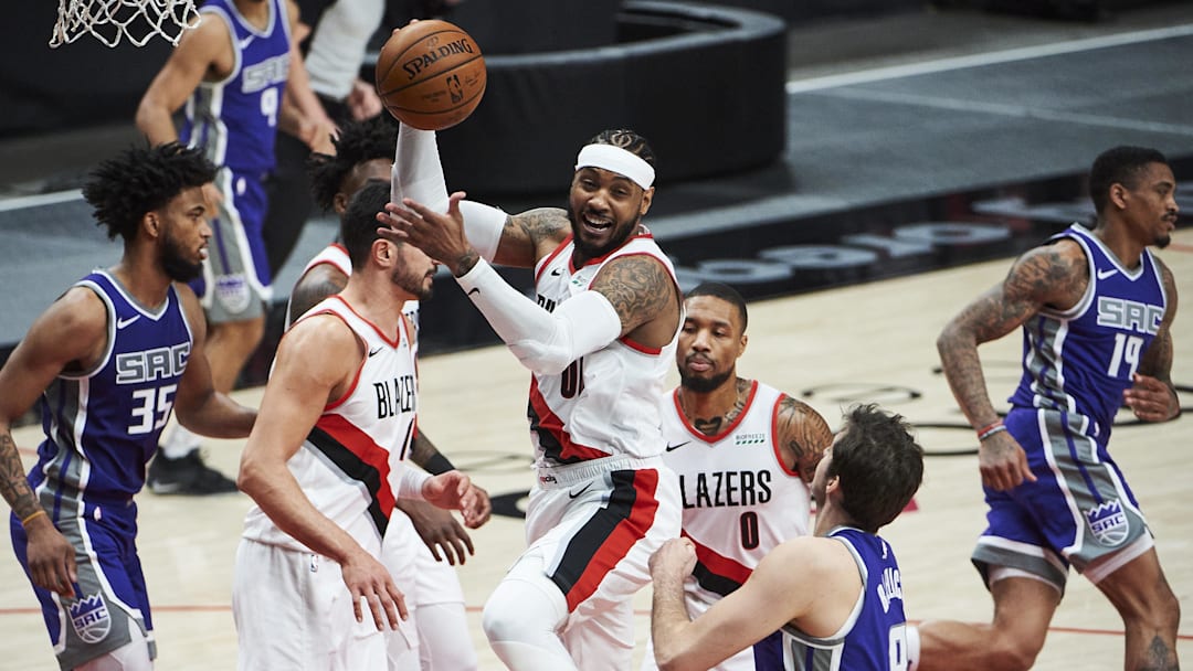 Mar 4, 2021; Portland, Oregon, USA; Portland Trail Blazers forward Carmelo Anthony (00) grabs a rebound against Sacramento Kings forward Nemanja Bjelica (8) during the first half at Moda Center. Mandatory Credit: Troy Wayrynen-Imagn Images