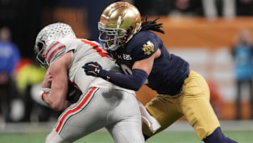 Jan 20, 2025; Atlanta, GA, USA; Notre Dame Fighting Irish safety Xavier Watts (0) tackles Ohio State Buckeyes quarterback Will Howard (18) in the second half in the CFP National Championship college football game at Mercedes-Benz Stadium. Mandatory Credit: Dale Zanine-Imagn Images