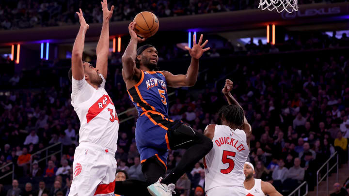 Jan 20, 2024; New York, New York, USA; New York Knicks forward Precious Achiuwa (5) drives to the basket against Toronto Raptors center Jontay Porter (34) and guard Immanuel Quickley (5) and forward Bruce Brown (11) during the first quarter at Madison Square Garden. Mandatory Credit: Brad Penner-USA TODAY Sports