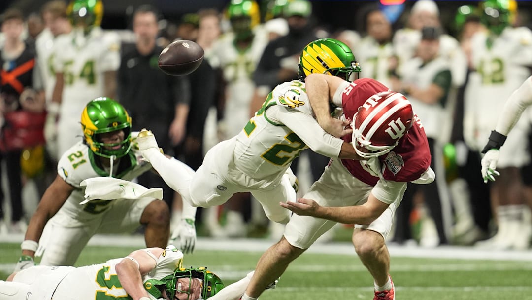 Jan 9, 2026; Atlanta, GA, USA; Oregon Ducks defensive back Jadon Canady (22) forces Indiana Hoosiers quarterback Fernando Mendoza (15) to fumble during the third quarter of the 2025 Peach Bowl and semifinal game of the College Football Playoff at Mercedes-Benz Stadium. Mandatory Credit: Dale Zanine-Imagn Images