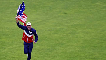 Sep 25, 2025; Bethpage, New York, USA; USA team captain Keegan Bradley runs an United States flag up the 18th fairway during a practice round of the Ryder Cup golf tournament at Bethpage Black. Mandatory Credit: Peter Casey-Imagn Images