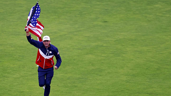 Sep 25, 2025; Bethpage, New York, USA; USA team captain Keegan Bradley runs an United States flag up the 18th fairway during a practice round of the Ryder Cup golf tournament at Bethpage Black. Mandatory Credit: Peter Casey-Imagn Images