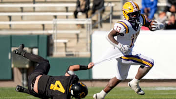 Dec 6, 2024; Birmingham, AL, USA; Cherokee County's Tristan Brown (4) tries to hang on for a tackle as Jackson's Ezavier Crowell (13) pulls away at Protective Stadium in the AHSAA 4A State Championship game.