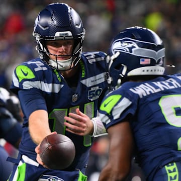 Oct 20, 2025; Seattle, Washington, USA; Seattle Seahawks quarterback Sam Darnold (14) hands the ball off to Seattle Seahawks running back Kenneth Walker III (9) during the third quarter against the Houston Texans at Lumen Field. Mandatory Credit: Steven Bisig-Imagn Images