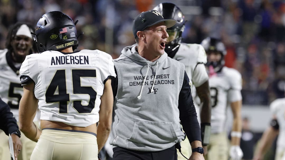 Nov 8, 2025; Charlottesville, Virginia, USA; Wake Forest Demon Deacons head coach Jake Dickert (center) celebrates with players after blocking a touchdown pass in the final seconds of the second half against the Virginia Cavaliers at Scott Stadium. Mandatory Credit: Amber Searls-Imagn Images