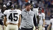 Nov 8, 2025; Charlottesville, Virginia, USA; Wake Forest Demon Deacons head coach Jake Dickert (center) celebrates with players after blocking a touchdown pass in the final seconds of the second half against the Virginia Cavaliers at Scott Stadium. Mandatory Credit: Amber Searls-Imagn Images
