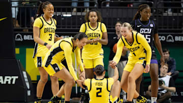 Oregon players help up teammate Oregon guard Katie Fiso after a foul as the Oregon Ducks host the Grand Canyon Antelopes Nov. 11, 2025, at Matthew Knight Arena in Eugene, Oregon.