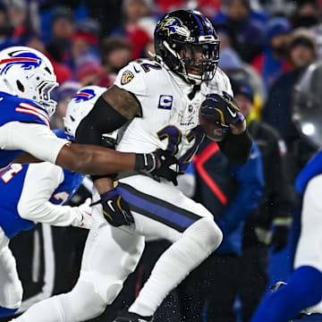 Jan 19, 2025; Orchard Park, New York, USA; Baltimore Ravens running back Derrick Henry (22) carries the ball as Buffalo Bills defensive end Greg Rousseau (50) attempts a tackle in the third quarter of a 2025 AFC divisional round game at Highmark Stadium. Mandatory Credit: Mark Konezny-Imagn Images