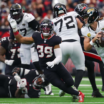 Nov 9, 2025; Houston, Texas, USA; Jacksonville Jaguars quarterback Trevor Lawrence (16) rolls out as Houston Texans linebacker Henry To'oTo'o (39) defends during the second half at NRG Stadium. Mandatory Credit: Thomas Shea-Imagn Images