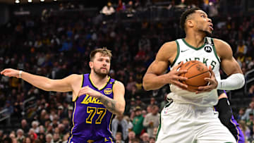 Mar 13, 2025; Milwaukee, Wisconsin, USA; Milwaukee Bucks forward Giannis Antetokounmpo (34) controls the ball against Los Angeles Lakers guard Luka Doncic (77) in the first quarter at Fiserv Forum. Mandatory Credit: Benny Sieu-Imagn Images