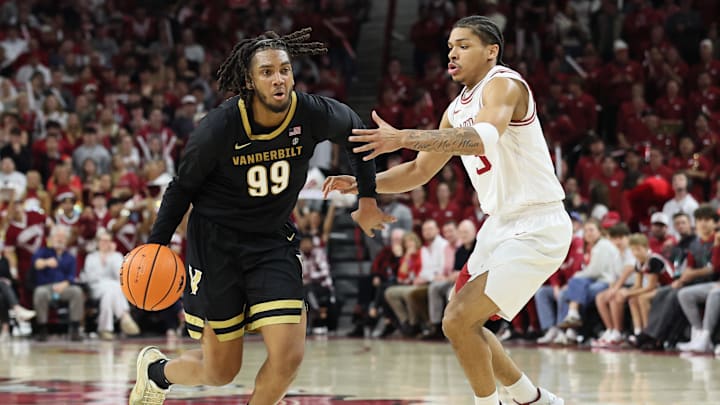 Jan 20, 2026; Fayetteville, Arkansas, USA; Vanderbilt Commodores forward Devin McGlockton (99) drives against Arkansas Razorbacks guard Darius Acuff Jr (5) during the second half at Bud Walton Arena. Arkansas won 93-68. Mandatory Credit: Nelson Chenault-Imagn Images