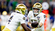 Jan 2, 2025; New Orleans, LA, USA; Notre Dame Fighting Irish running back Jeremiyah Love (4) hands the ball to Notre Dame Fighting Irish quarterback Riley Leonard (13) during the first quarter at Caesars Superdome. Mandatory Credit: Stephen Lew-Imagn Images