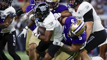 Aug 31, 2024; Seattle, Washington, USA; Washington Huskies edge Zach Durfee (5) tackles Weber State Wildcats running back Damon Bankston (1)during the second quarter at Alaska Airlines Field at Husky Stadium. Mandatory Credit: Joe Nicholson-Imagn Images