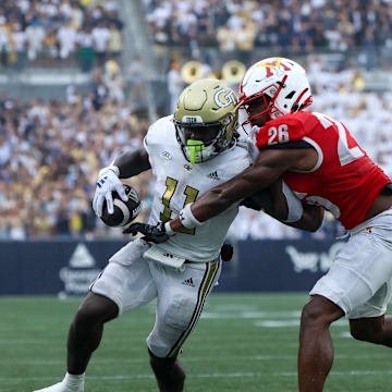 Sep 14, 2024; Atlanta, Georgia, USA; Georgia Tech Yellow Jackets running back Jamal Haynes (11) has the ball stripped by Virginia Military Institute Keydets defensive back Kouri Crump (26) in the second quarter at Bobby Dodd Stadium at Hyundai Field. Mandatory Credit: Brett Davis-Imagn Images