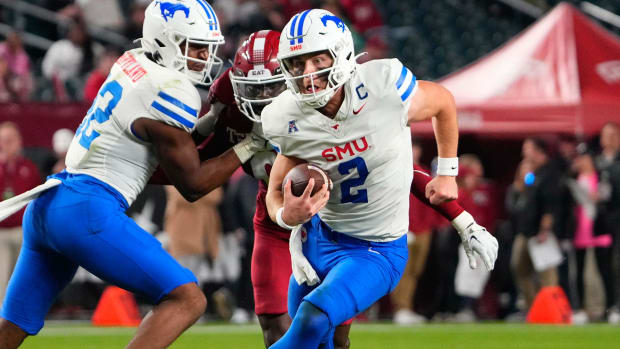 SMU Mustangs quarterback Preston Stone runs with the ball during a college football game.