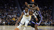 Oct 18, 2023; San Francisco, California, USA; Golden State Warriors forward Jonathan Kuminga (00) drives past Sacramento Kings guard Malik Monk (0) during the fourth quarter at Chase Center. Mandatory Credit: D. Ross Cameron-Imagn Images