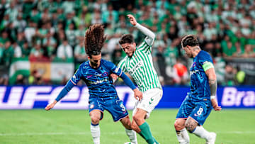 USMNT midfielder Johnny Cardoso being surrounded by two Chelsea players while playing for Real Betis in the 2025 UEFA Conference League Final.