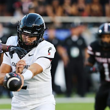 Sep 28, 2024; Lubbock, Texas, USA;  Cincinnati Bearcats quarterback Brandan Sorsby (2) hands the ball in the first half to running back Coey Kiner (21) during the game against the Texas Tech Red Raiders at Jones AT&T Stadium and Cody Campbell Field. Mandatory Credit: Michael C. Johnson-Imagn Images