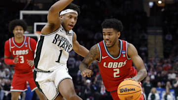 Mar 23, 2025; Cleveland, OH, USA; New Mexico Lobos guard Donovan Dent (2) dribbles the ball defended by Michigan State Spartans guard Jeremy Fears Jr. (1) in the second half during the NCAA Tournament Second Round at Rocket Arena. Mandatory Credit: Rick Osentoski-Imagn Images