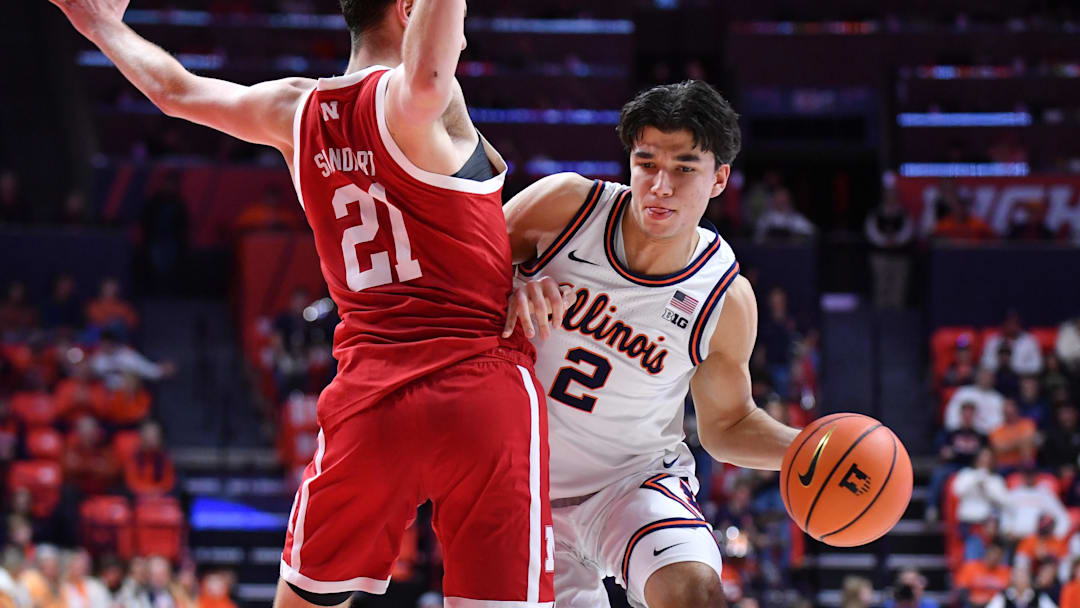 Dec 13, 2025; Champaign, Illinois, USA; Illinois Fighting Illini guard Andrej Stojakovic (2) drives the ball around Nebraska Cornhuskers forward Pryce Sandfort (21) during the first half at State Farm Center. Mandatory Credit: Ron Johnson-Imagn Images